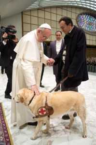 Pope Francis I greets a man with a guide dog as he conducts a general audience in the Paul VI hall for members of the media at the Vatican